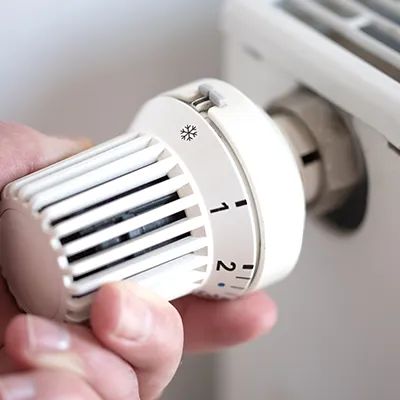 Symbolbild mit Heizkörper und Temperaturregler