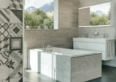 modernes Bad mit Mosaik-Fliesen, Badewanne und hellen Badmöbeln